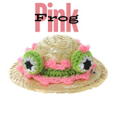 The frog eyes on the straw hat are knitted from green wool with a hint of pink around them.